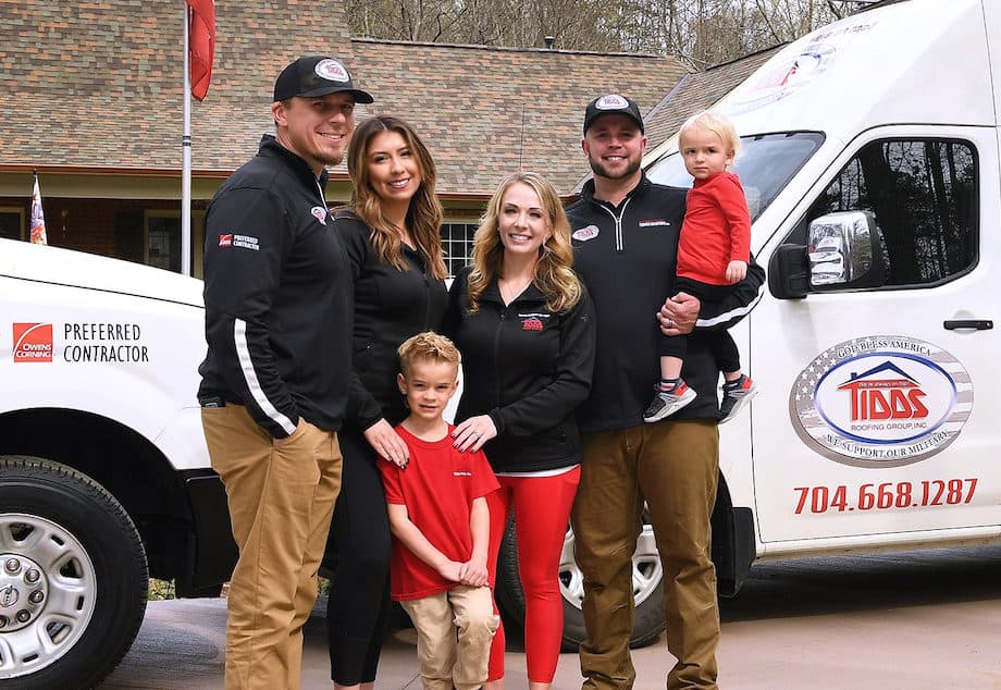 tidds family standing in front of branded company trucks
