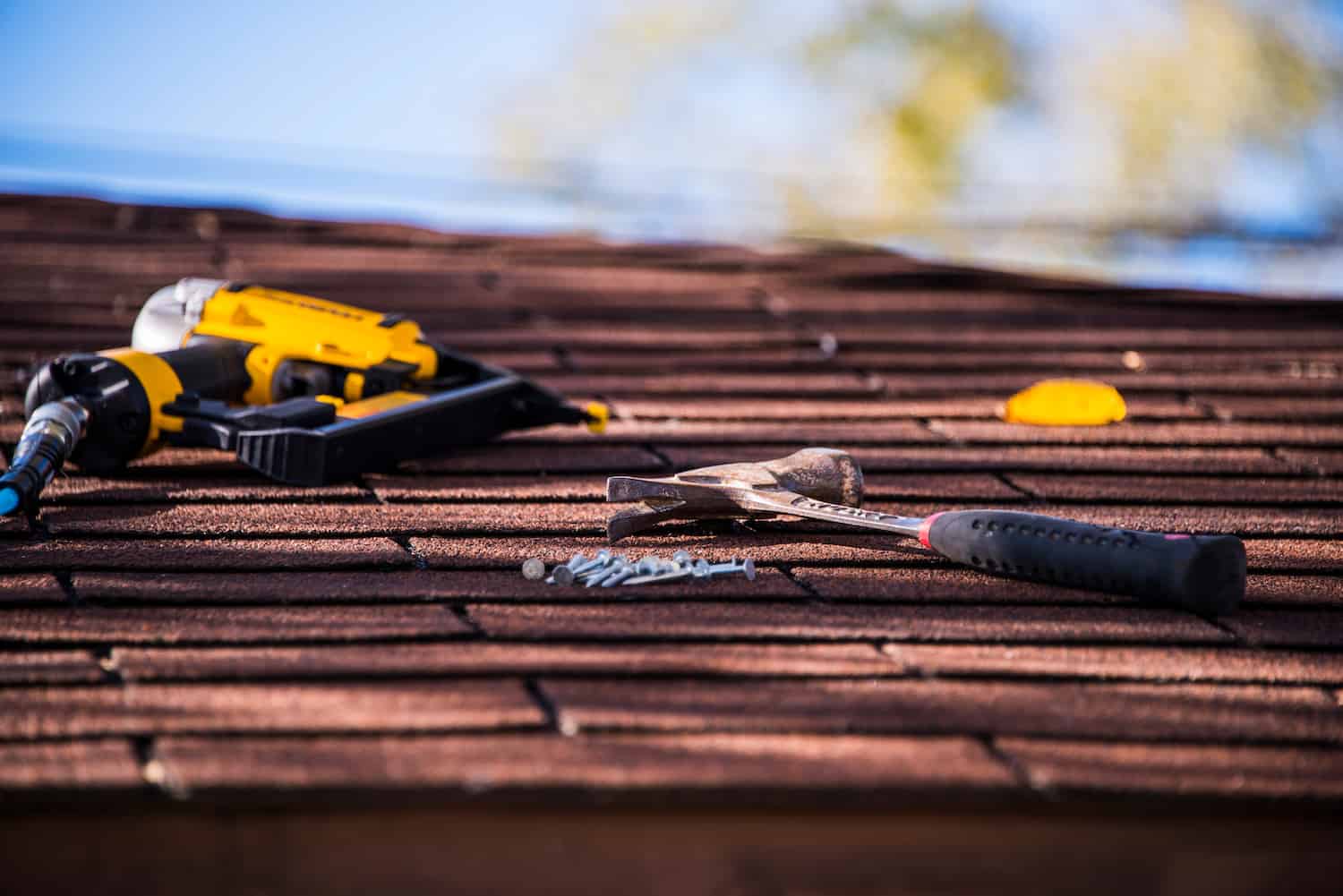 Roof shingle repair with nail gun and hammer