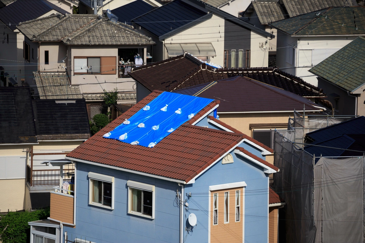 tarp on top of a roof in a neighborhood