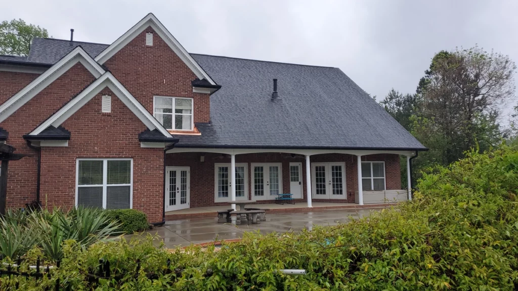 brick house with black roof shingles 
