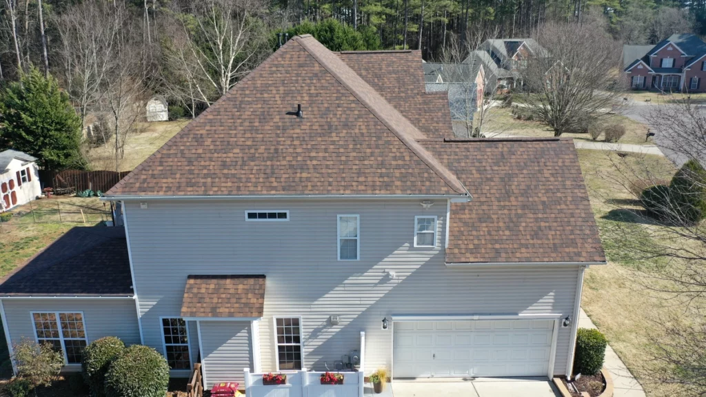  asphalt shingle roof replaced with warm tone shingles on white siding house