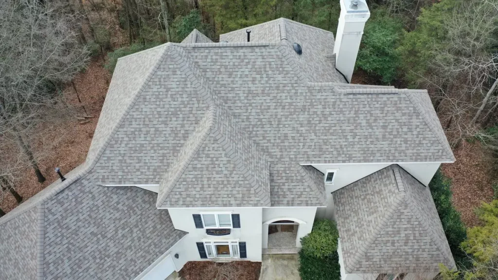 large house with gray asphalt shingles and trees in the backyard