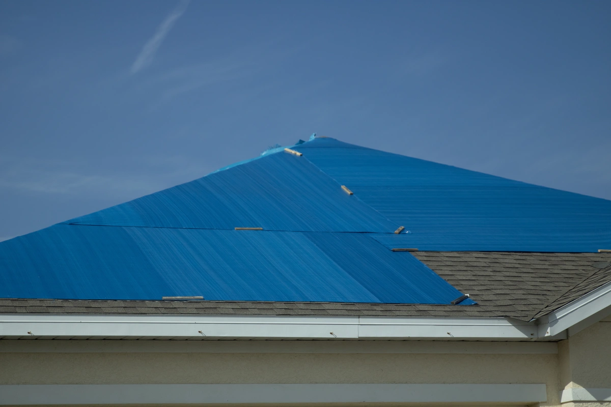 tarp fully covering damaged parts of a roof