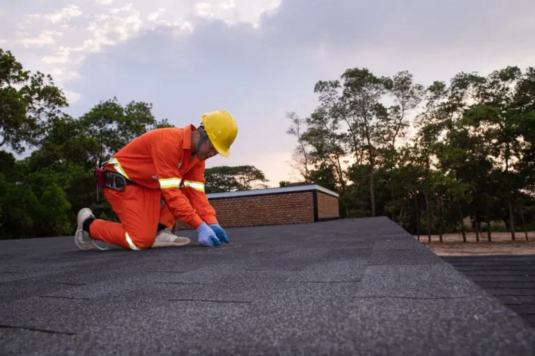 professional worker repairing the roof asphalt shingle